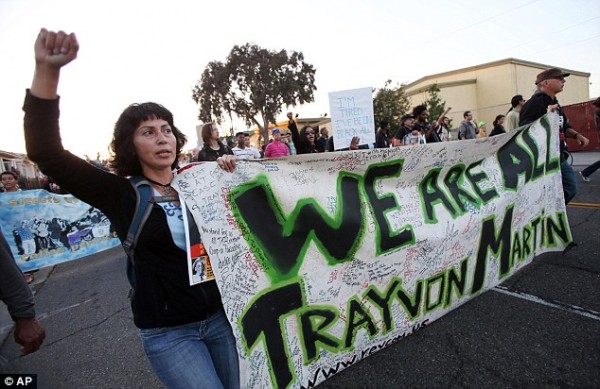People march through Oakland, California, as part of the Justice for Trayvon rally