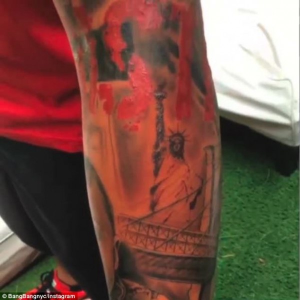The tattoo includes New York landmarks including the Statue of Liberty