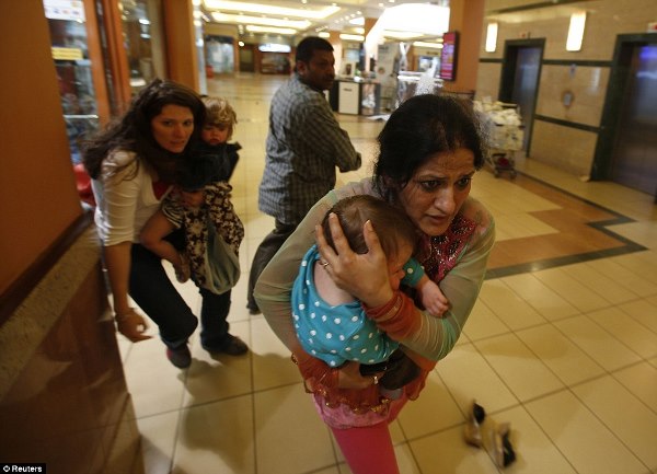 Women carrying children run for safety after al Shabaab terrorists stormed Westgate shopping center in Nairobi, Kenya armed with guns and grenades