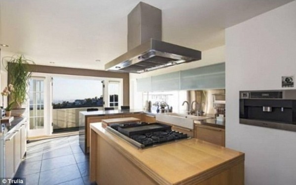 The kitchen features an island bench and a rather epic view of the city 1