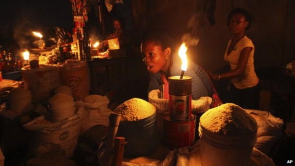A Lagos Trader selling her goods in the darkness. Photo: AP