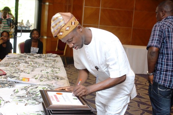 NECLive 2014 - Ayeni Adekunle signing the NET Honours plaques