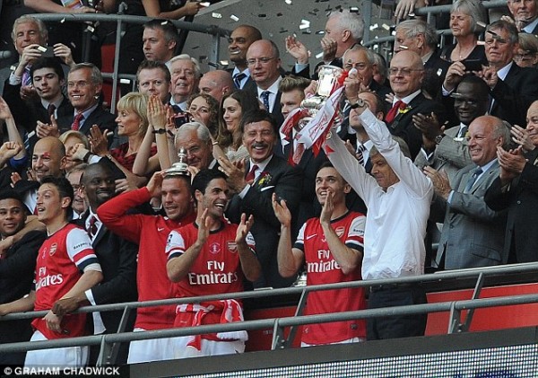 Arsenal boss Arsene Wenger proudly lifts the FA Cup after his side's dramatic 3-2 win against Hull