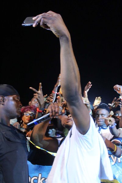 Selfie: Sean Tizzle takes a snap shot with the crowd.