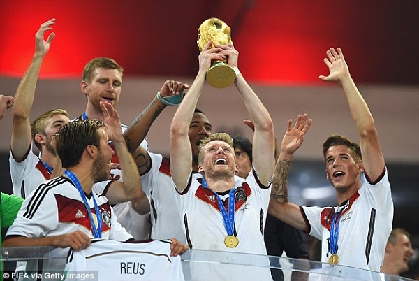 Andre Schurrle lifts the famous trophy, a replica of which was later damaged by his team. Photo: Daily Mail