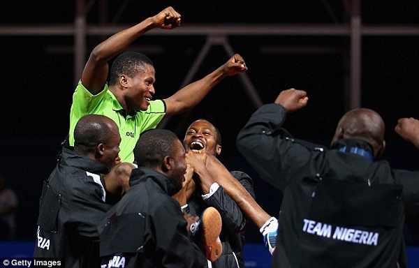 Ojo Onaolapo celebrates with his team-mates after winning the men's team table tennis bronze medal match