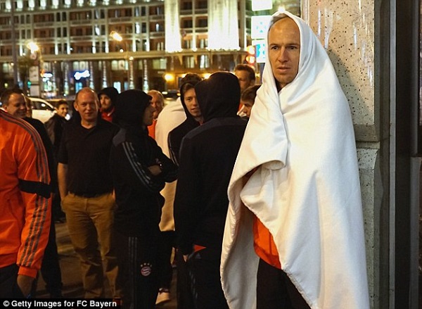 Arjen Robben huddles under a blanket after a fire alarm forced Bayern Munich to evacuate their hotel