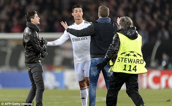 Cristiano Ronaldo takes up an argument with two fans who invaded the pitch to confront the Real Madrid star