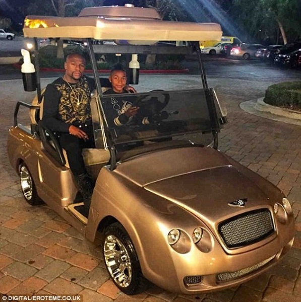 Floyd Mayweather poses for a photo with his son Koraun on his birthday in his new gold Bentley golf cart