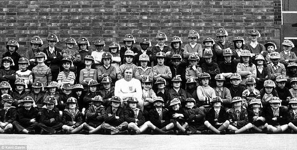 Sir Bobby Moore marks his century of caps in 1973 with a group of schoolchildren. Moore went on to win 108 caps for England