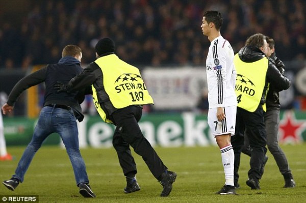 Stewards quickly intervened to lead the supporters off the pitch as Ronaldo looks on following the incident