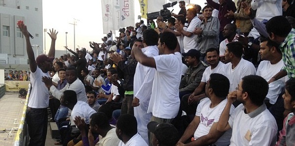 A man whips up a crowd which included migrant workers from Africa and Asia who said they were paid to attend the Qatar Open of international beach volleyball