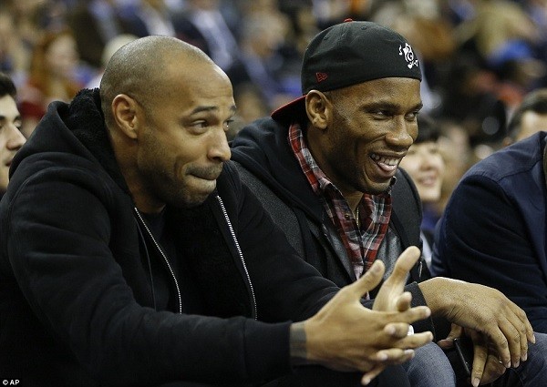 Chelsea centre-forward Didier Drogba (right) laughs as he takes his courtside seat alongside Henry