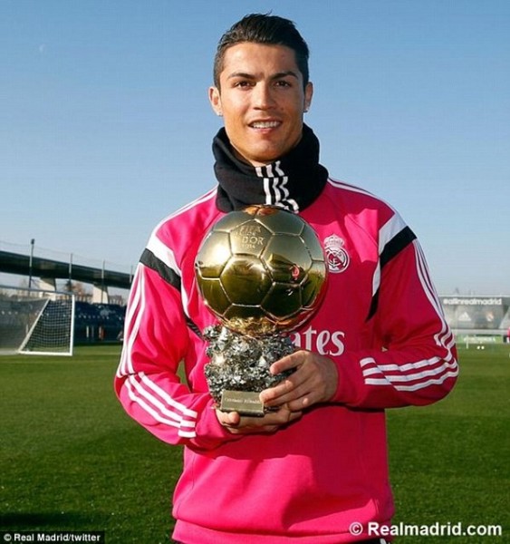 Cristiano Ronaldo poses with his Ballon d'Or trophy as he returns to training with Real Madrid on Tuesday