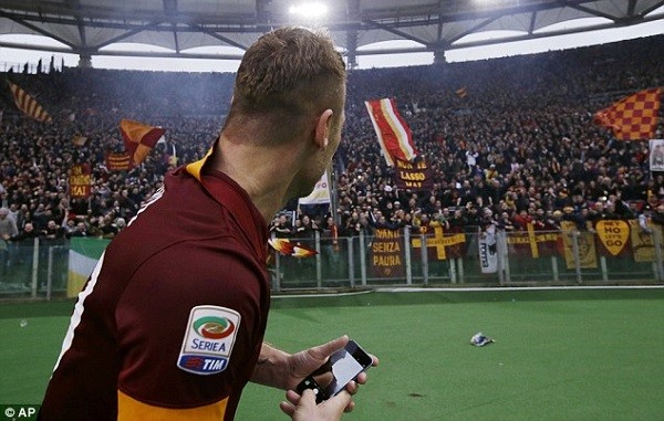 Former Italy international Totti holds a mobile phone before taking a celebratory selfie