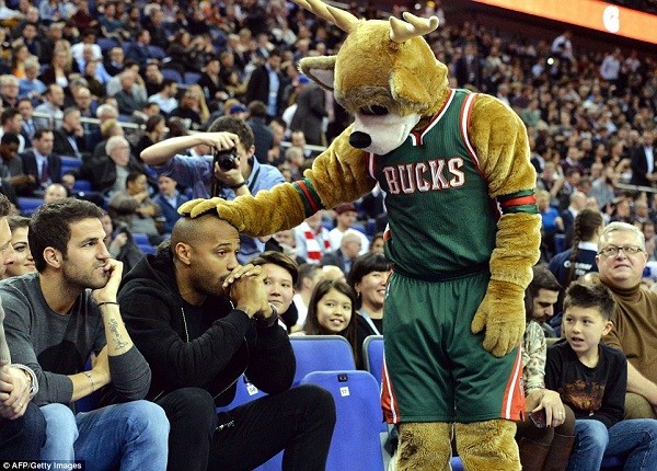 Henry looks less than impressed as Milwaukee mascot Bango rests a hand on his head before the start of the game