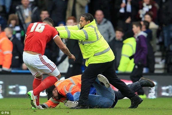 Lascelles is pushed away by the steward while another jumps on top of the attacker