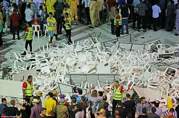 Security guards stand around a pile of plastic chairs and tables after spectators threw them