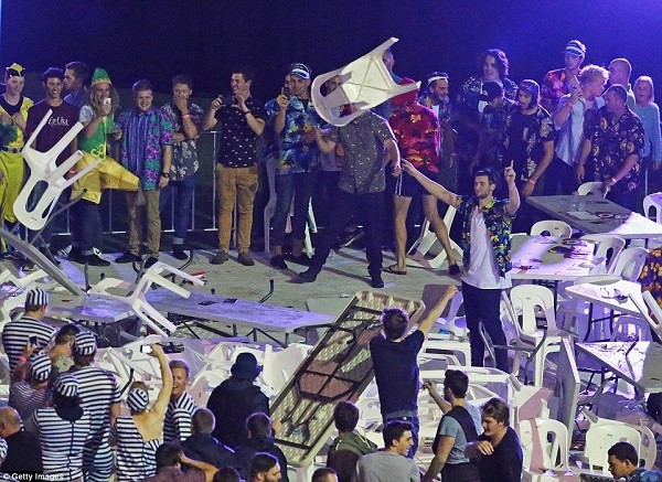 Spectators throw plastic chairs and tables during the final between Whitlock and Van Gerwen