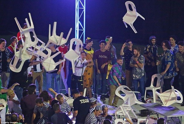 Tables and chairs are thrown as match stewards struggle to regain control of the situation