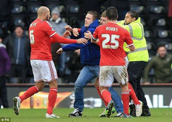 Wilson goes back in to confront the fan over the attack while his team-mates attempt to restrain the man
