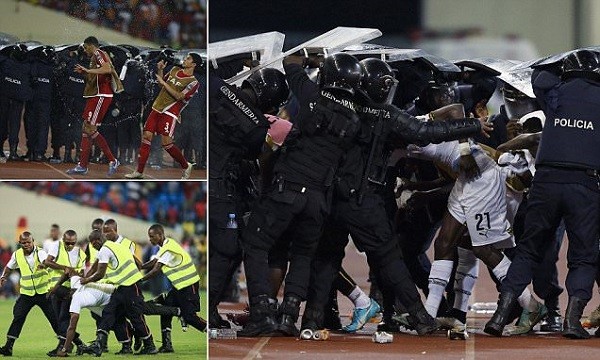 Riot police shield Ghana's John Boye and team mates from objects thrown by Equatorial Guinea fans at the end of the first half of the 2015 African Cup of Nations semi-final soccer match in Malabo