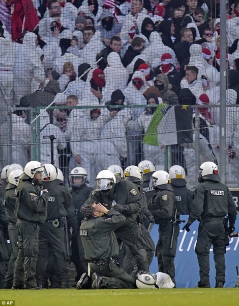 A policeman was injured after fans threw flares and stormed the pitch after Cologne's 1-0 defeat