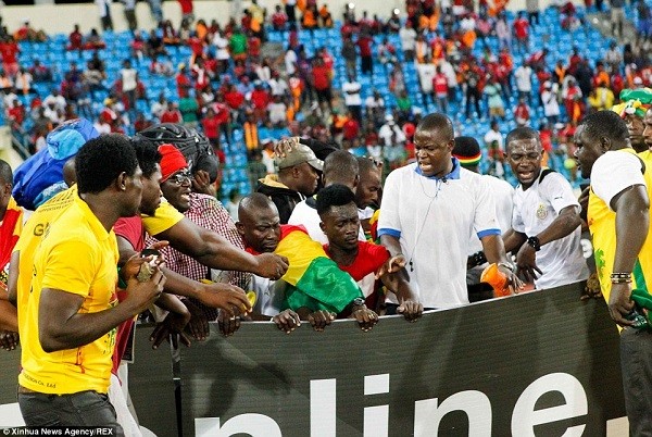 Ghana fans were forced to take cover by the side of the pitch after the home fans pelted them with missiles in the stands