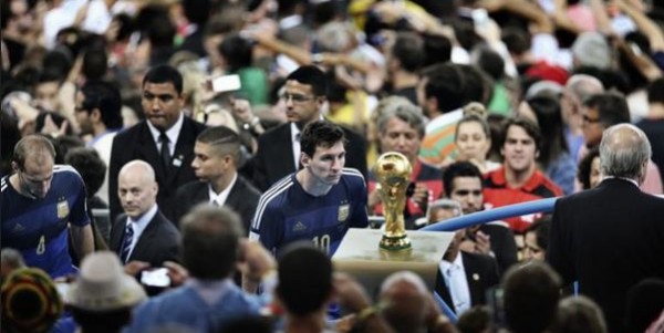Lionel Messi starring at the World Cup trophy