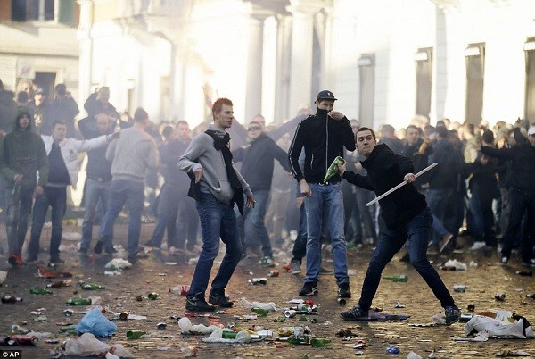 One supporter picks up a bottle to throw from amid the smoke and broken bottles that littered the area around Rome's Spanish Steps