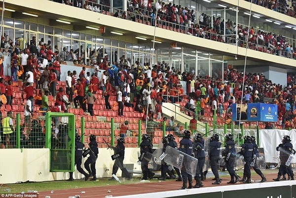 Police dressed in riot gear make their way into the stands with shields and batons drawn in an effort to calm the rioting home supporters