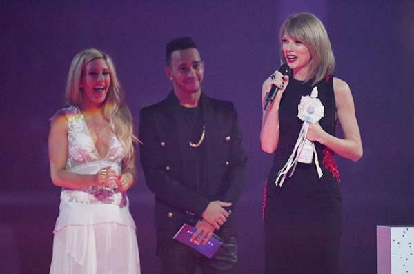 Taylor Swift with her Best International Female Solo Artist award and presenters Ellie Goulding and Lewis Hamilton on stage during the Brit Awards 2015. Photo: Billboard