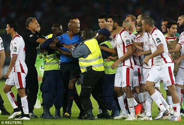 The Tunisia players continue to hassle referee Rajindraparsad following the full time whistle