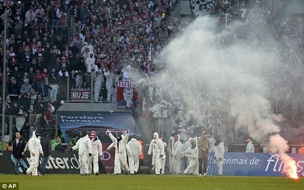 The men, dressed all in white, threw flares onto the pitch and then at the players leaving the field