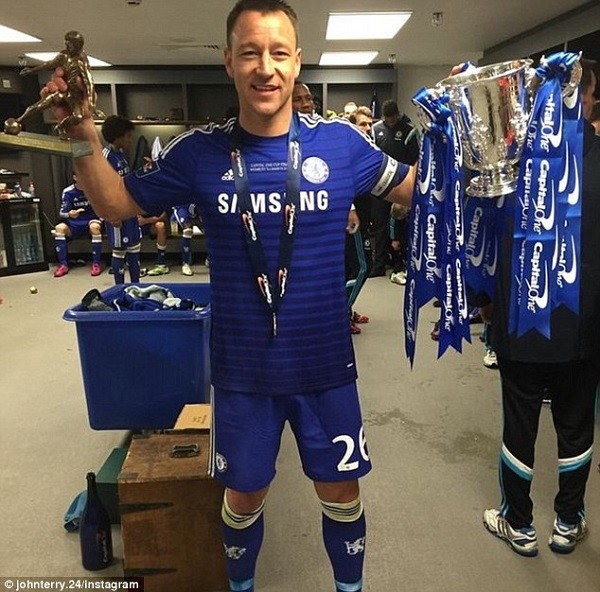 John Terry holds up his man of the match award and the Capital One Cup after the game