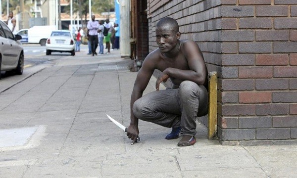 A foreign national holds a knife following clashes between a group of locals and police in Durban amid ongoing violence against foreign nationals. Photo AFP