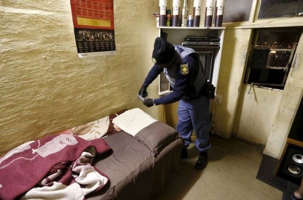 A policeman examines a handgun found during a raid on a hostel in Johannesburg's Alexandra township April 23, 2015