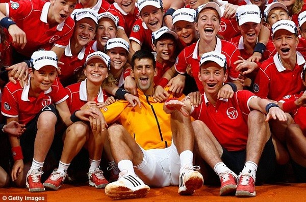 Djokovic celebrates with ball boys and girls after victory in the Rolex Masters