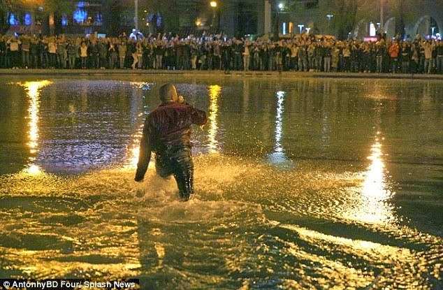 (As paparazzi scrambled to get a picture, security guards pulled Kanye out from the group of fans and police stopped the gig. Photo: Daily Mail)