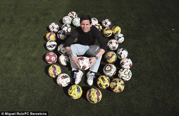 Lionel Messi poses with each of the 32 balls he has taken home after scoring a hat-trick for Barcelona