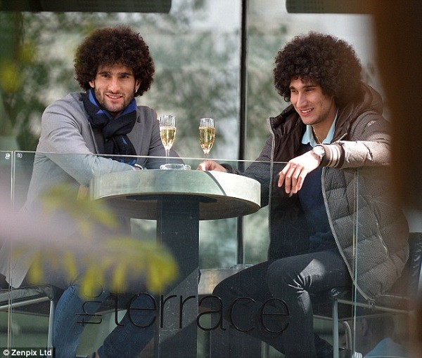 Marouane Fellaini (left) and his twin brother Mansour share a glass of bubbly in Manchester