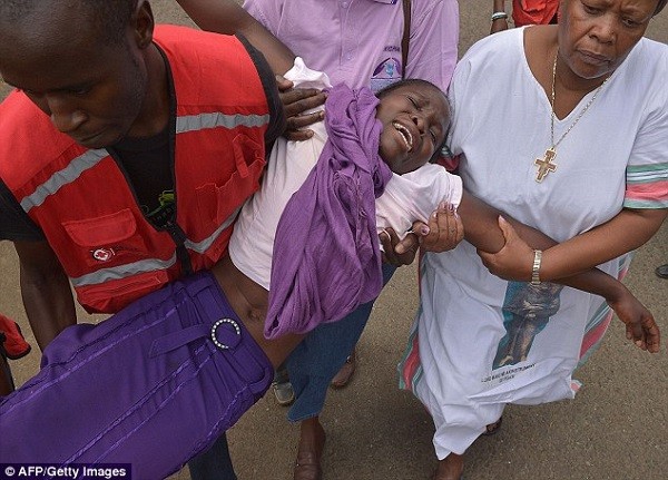 Members of the Red Cross help a woman overcome with grief after seeing the body of a relative