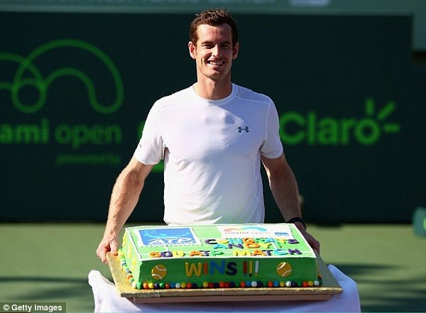 Murray proudly poses with the cake, saying 'It's an amazing feeling' after reaching the 500 club