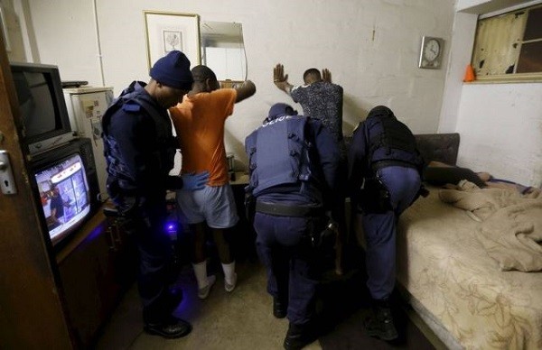 Police search local residents during a raid on a hostel in Johannesburg's Alexandra township April 23, 2015.