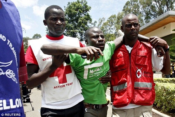 The relative of a victim is helped by Red Cross staff as bodies of students killed on Thursday's attack arrive at the Chiromo Mortuary in Nairobi