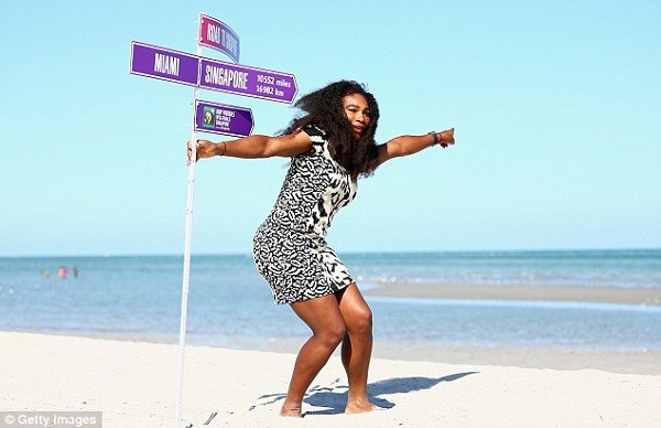Williams poses with the road to Singapore sign post on Crandon Park beach after her straight-sets victory