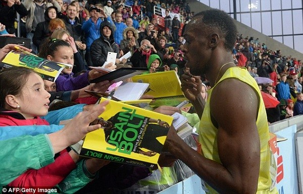 Bolt signs autographs in the crowd following his victory in Ostrava