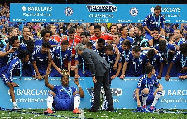 Chelsea striker Didier Drogba wears the crown from the trophy as he poses with his team-mates during the presentation