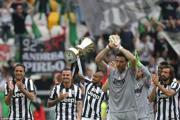 Chilean forward Arturo Vidal lifts the trophy as his Juventus team-mates, including Andrea Pirlo (right) applaud the fans