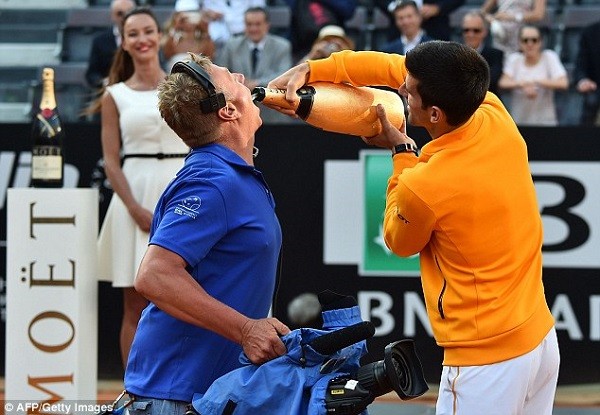 Djokovic gives Champagne to a cameraman after winning the Foro Italico in Rome
